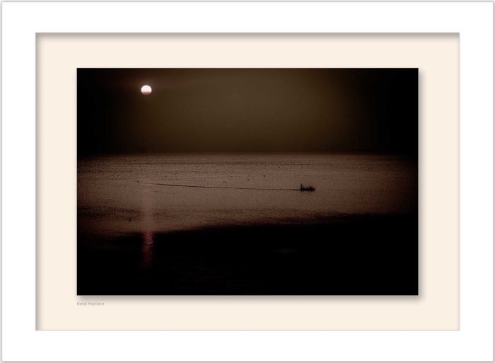 Framed Minimal photograph of a small boat on a calm lake at sunset